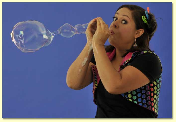 bernadette the Bubble Lady blowing a long soap bubble with her bare hands.