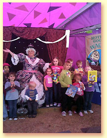 Photograph of Mother Goose with children holding Mother Goose books at the Texas State Fair.