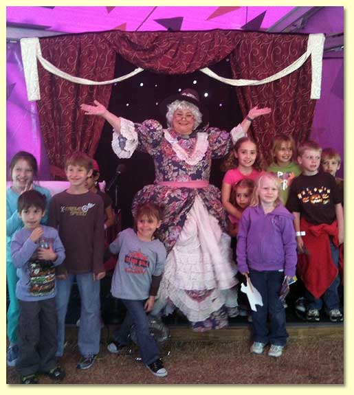 Mother Goose stands at the doorway to the children's Storytime tent, welcoming gusts to enjoy the show.